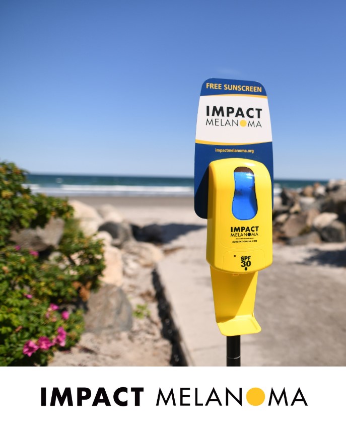 A Sunscreen dispenser outside from Impact Melanoma with the words 