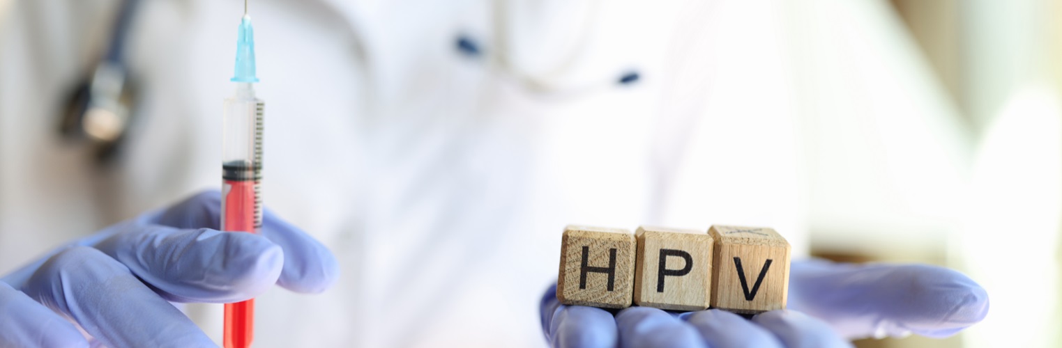 nurse holds needle and blocks that spell out 