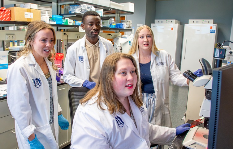 DNRM Graduate students in lab looking a computer screen.