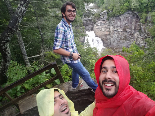 Residents enjoying the great outdoors, standing in front of a waterfall