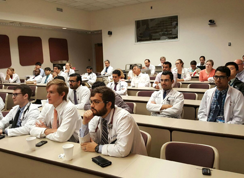 Residents sitting at desks listening intently to a lecture