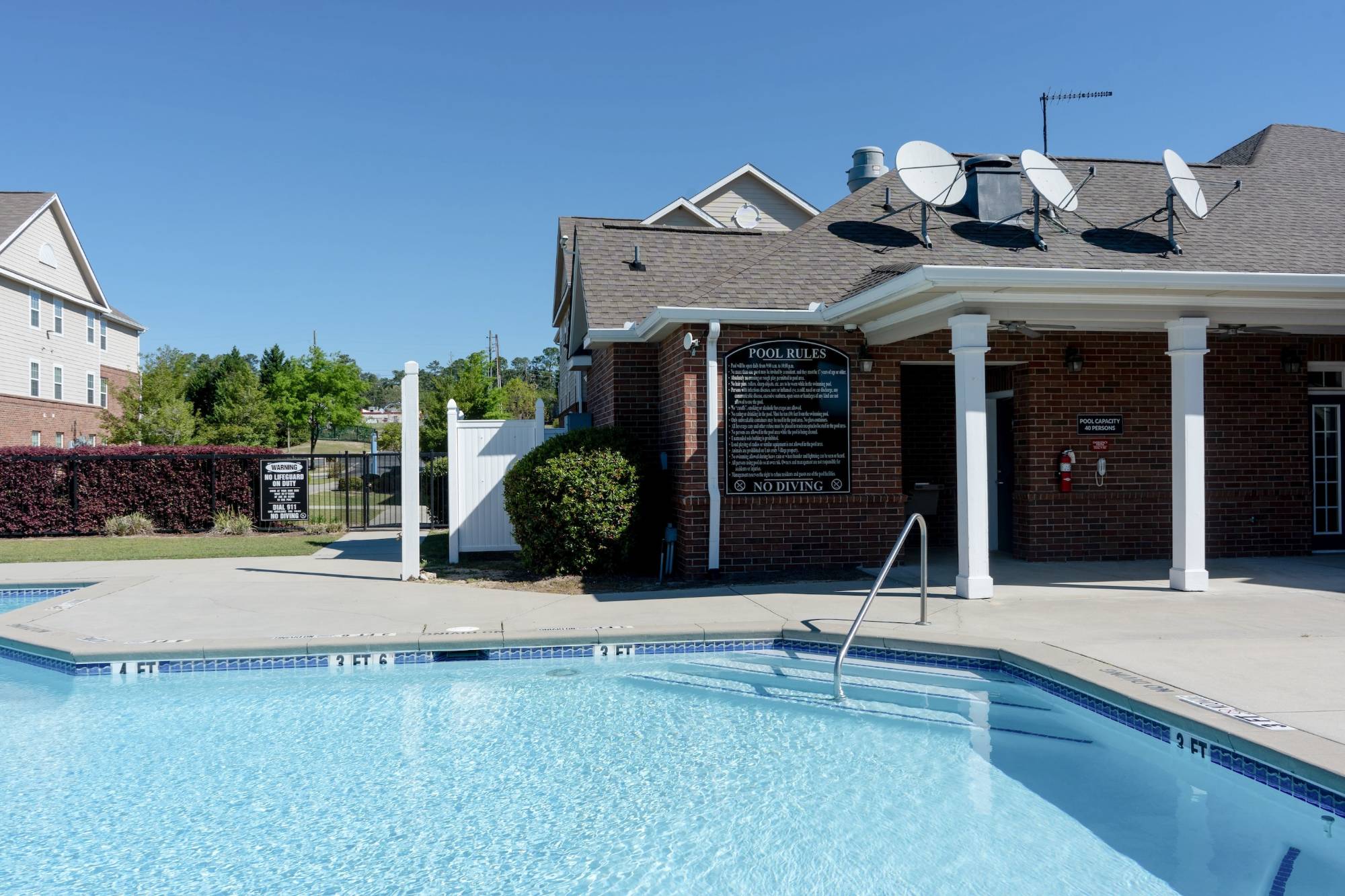 Close up of the pool at University Village showing gateway entry with apartments in the background.