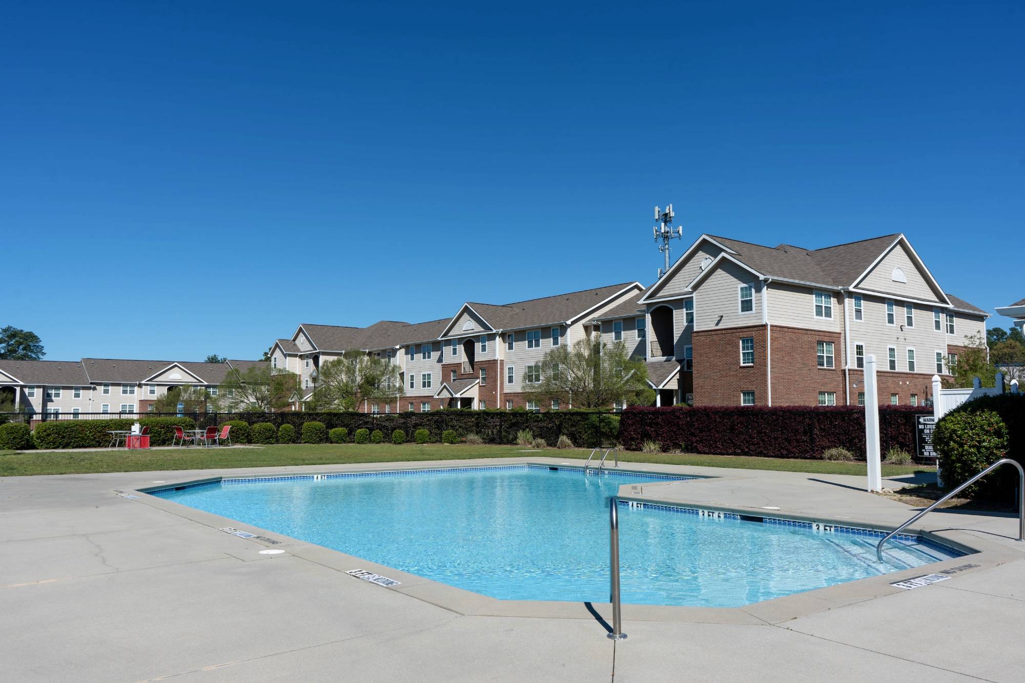 Pool in the foreground, surrounded by University Village student apartments